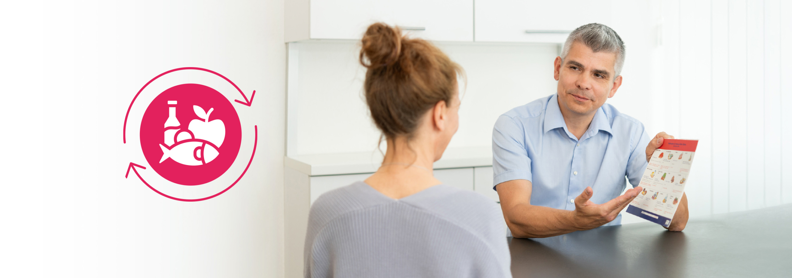 Ein Ernährungsberater erklärt einer Klientin wichtige Informationen zu gesunder Ernährung, während er ein Informationsblatt mit Lebensmittelauswahl präsentiert. Im Hintergrund ist ein Symbol für nachhaltige Ernährung zu sehen.